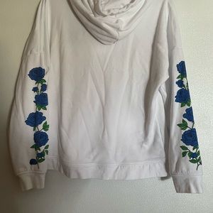 EMPYRE LARGE WOMANS HOODIE WITH POUTCH ON FRONT. BLUE ROSES DOWN SLEEVES WHITE